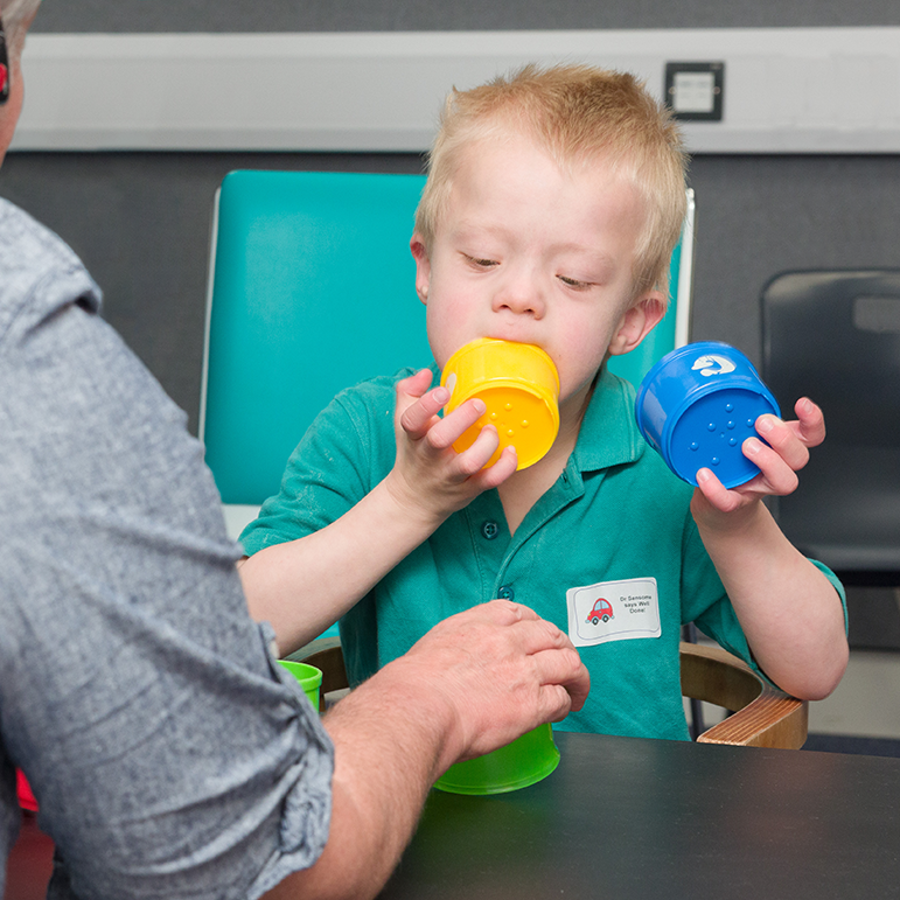 Downs syndrome child mouthing plastic cups 