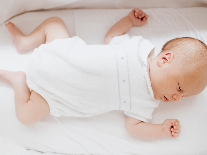 Baby lying on back in crib