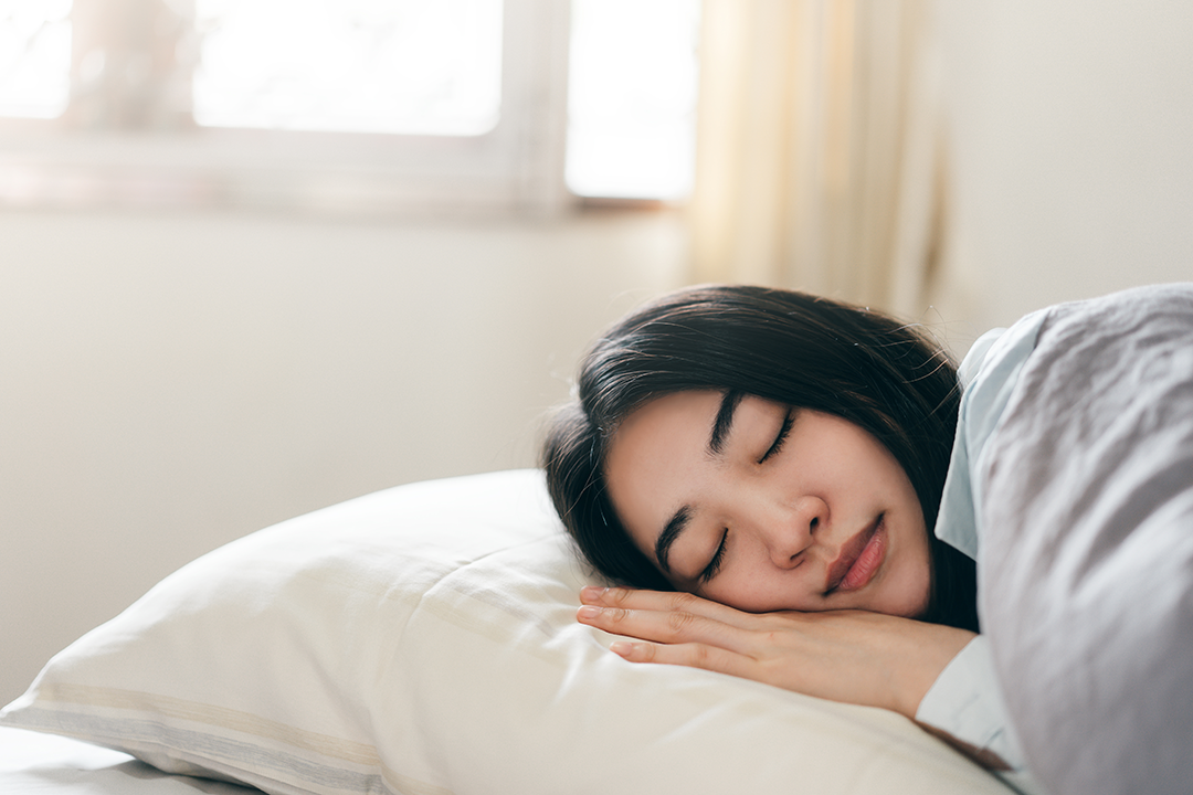 teenager sleeping on pillow with bright daylight outside