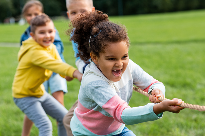 children playing tug of war in a field