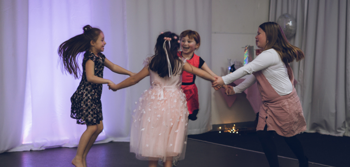 4 girls dancing together and holding hands in a circle