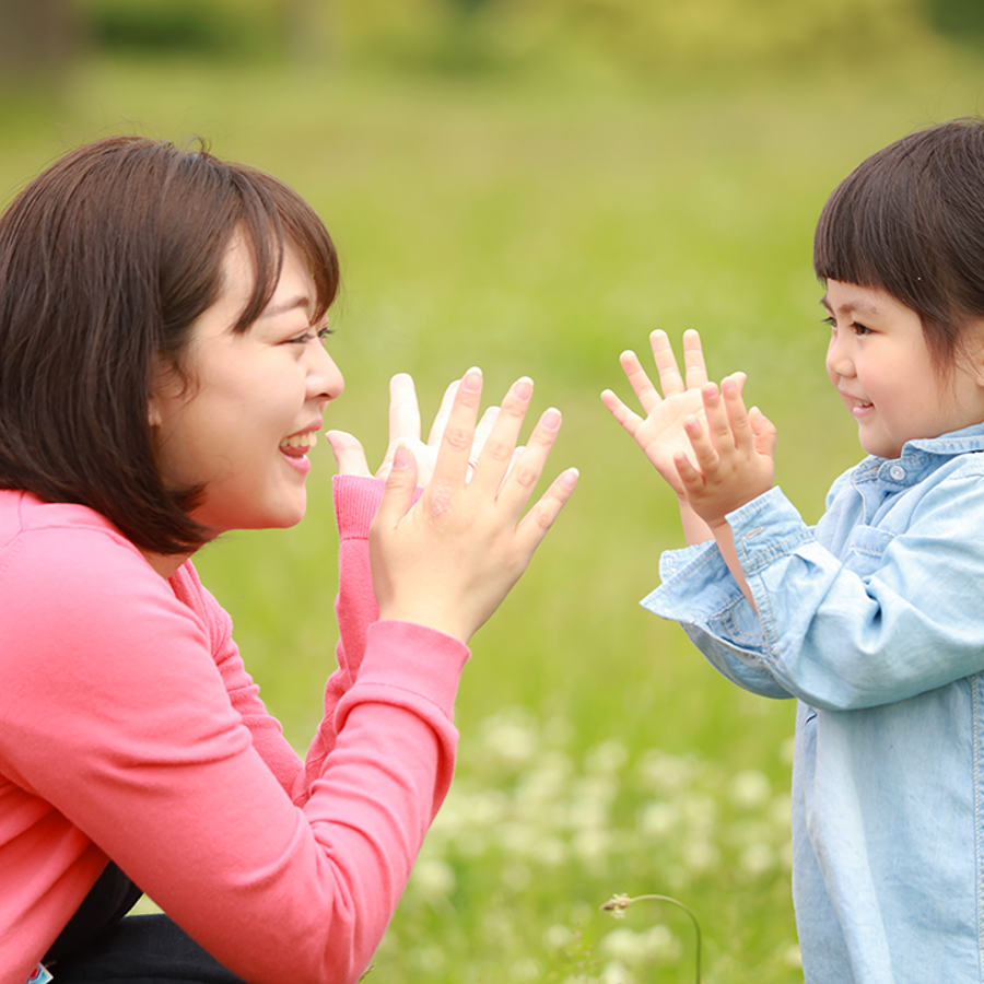 Child and adult outside clapping.