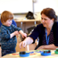 Child with Down's syndrome painting with an adult at a table