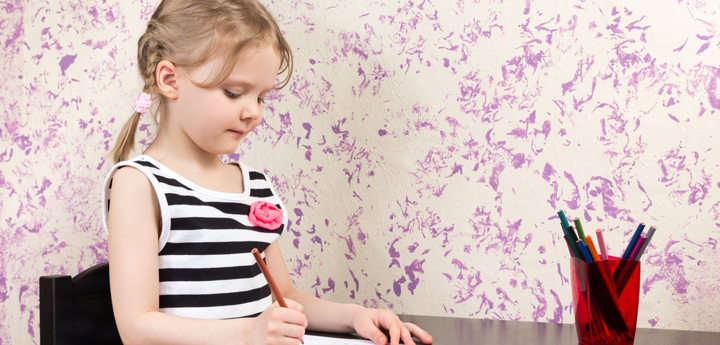 Child sitting at a table drawing