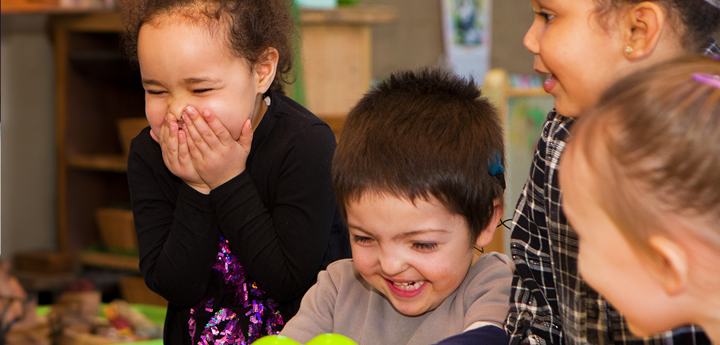 Four children laughing and smiling together.