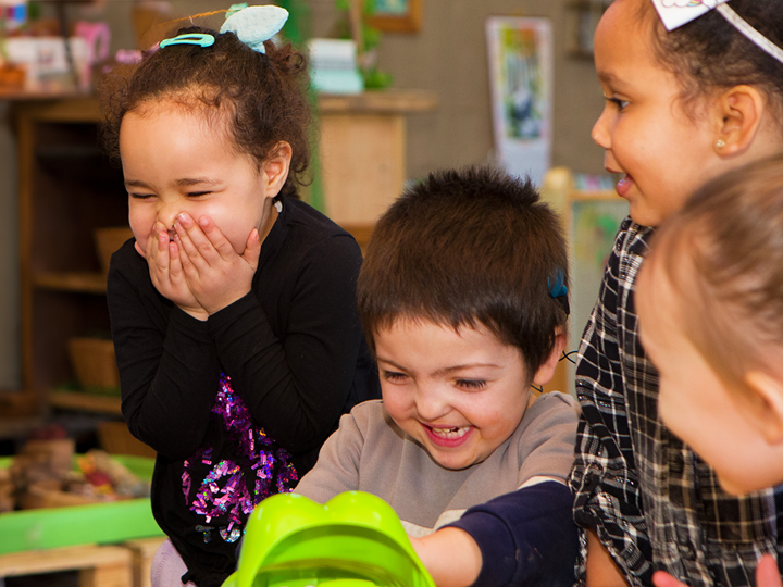 Four children laughing and smiling together.