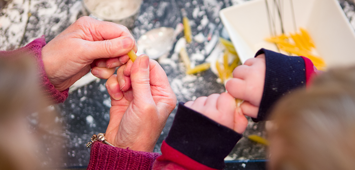 Showing only their hands. Adult and child playing with food. 