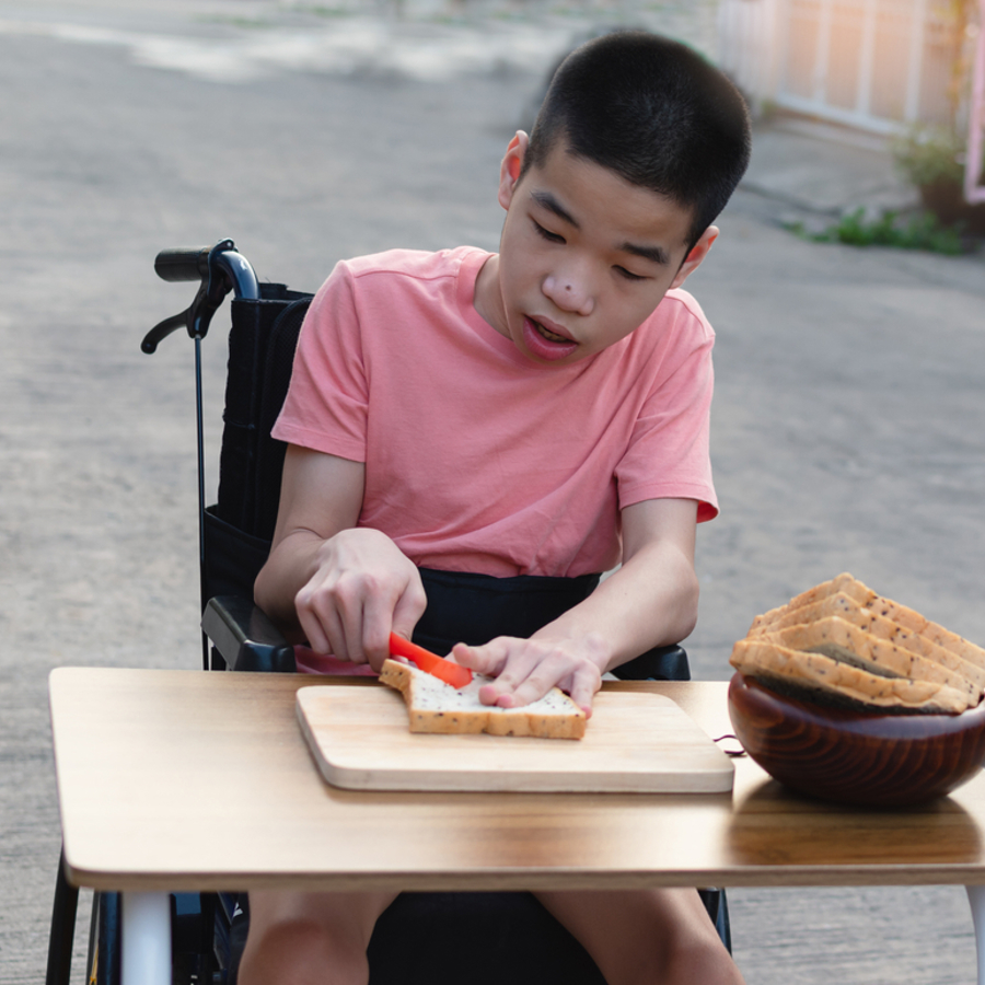 Child with cerebral palsy buttering bread