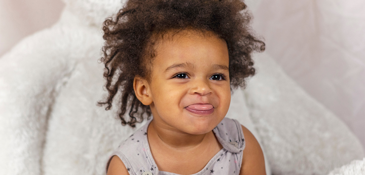 Young child sticking their tongue out with a cheeky smile